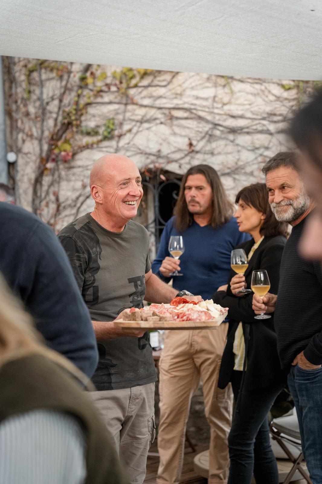 Manu servant une planche de charcuterie aux convives